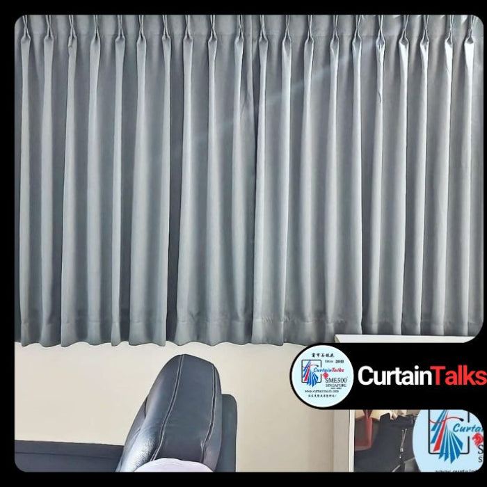 A half height black curtain hanging on a window 